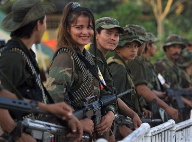 ¿Mejoramiento?~EL PAÍS. (2017, 30 noviembre). [Una guerrillera de las Fuerzas Armadas Revolucionarias de Colombia (FARC) sonríe a un compañero.]. EL PAÍS. https://elpais.com/elpais/2017/11/30/album/1512064159_410116.html#foto_gal_10