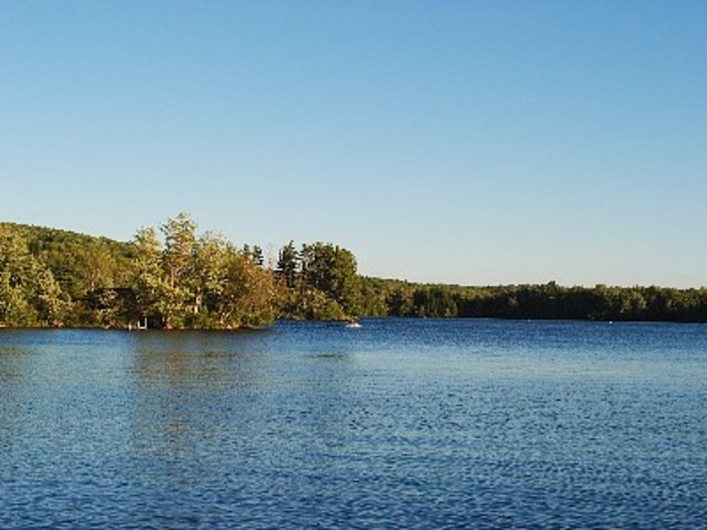 En campamiento, esquí en la agua con un barco. El lago es muy bonita y tenió muchas barcos.