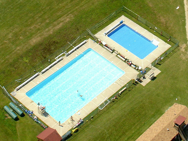 Nadé en la piscina. La piscina esta alado de el lago y la piscina es azul.