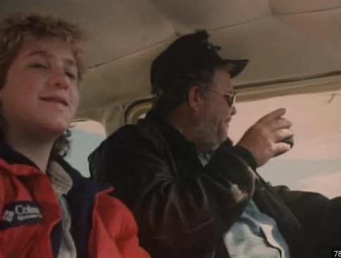 During the plane ride, the pilot has a heart attack and dies.