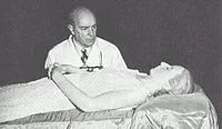 Eva's body undergoes embalming by Dr. Pedro Ara to preserve it for public viewing.