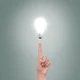 Index finger pointing illuminated bulb