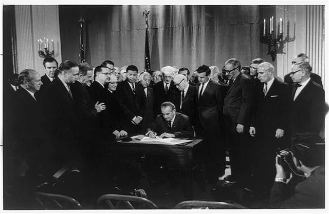 President Johnson signs the civil rights act.