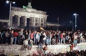Caída del Muro de Berlín, simbolizando el colapso de regímenes comunistas y la apertura religiosa en Europa del Este.
