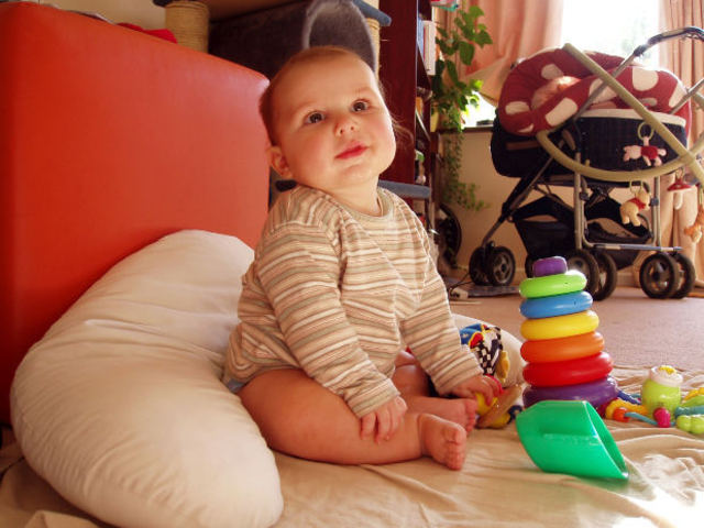 A baby can hold its head up and reach for objects.