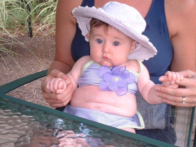 A baby can hold its head up and reach for objects.