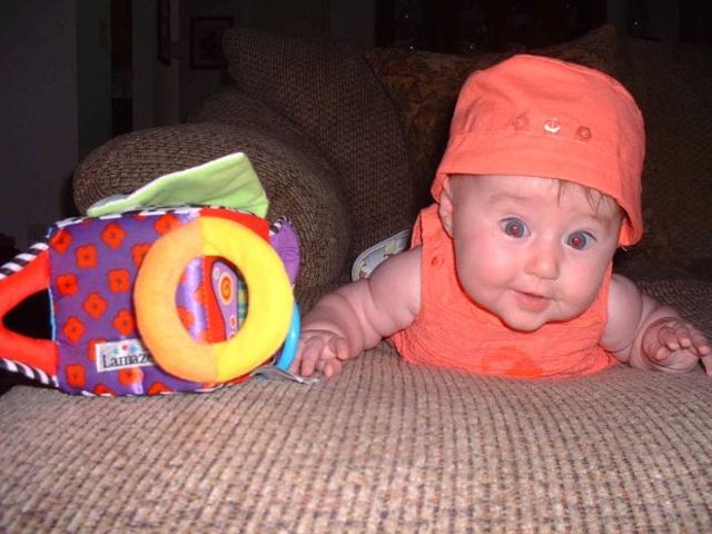 A baby can hold its head up and reach for objects.