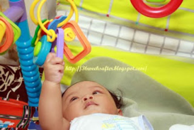 A baby can hold its head up and reach for objects.