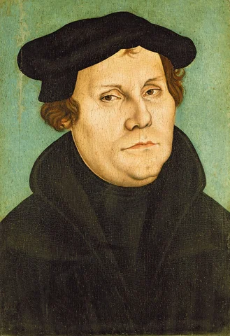 Martin Luther writing the Ninety-Five Theses