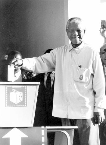 Mandela votes for the first time in South Africa's first democratic election.