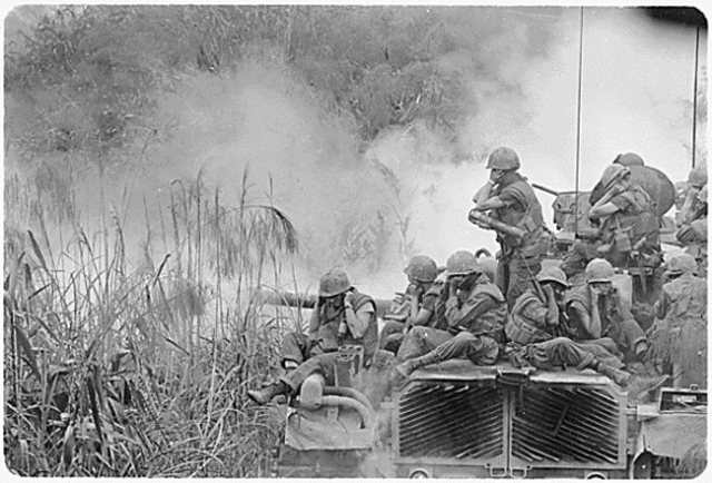 Marines ride on a M-48 tank.