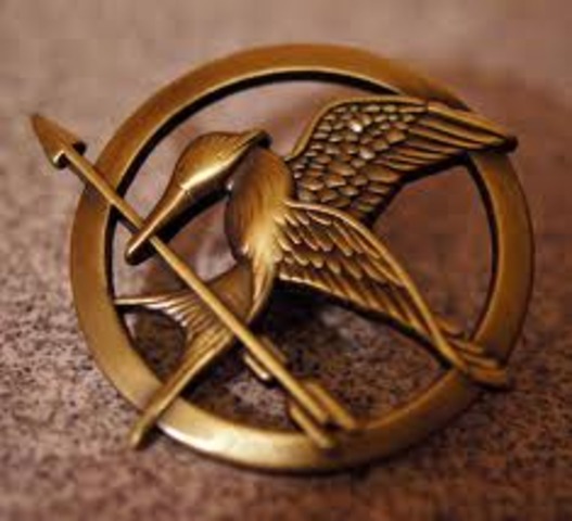 Cinna Gives Katniss the Mokayingjay Pin -mm5624