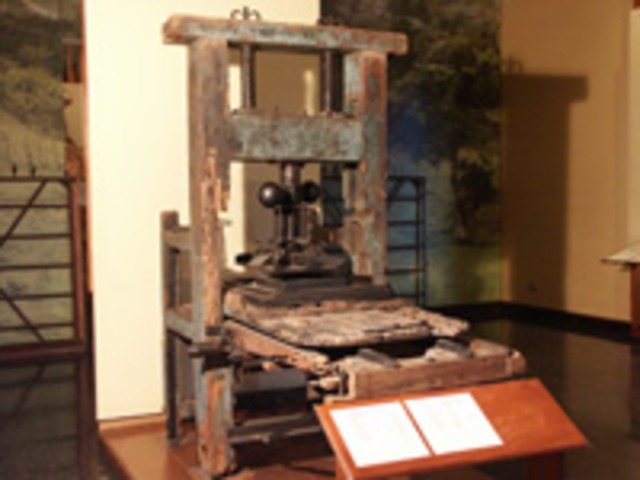 máquina hecha de madera y hierro  se trata de la primera imprenta que vino a Costa Rica introducida por  el señor Miguel Carranza Fernández político y empresario costarricense de la época, quien le puso el nombre de “Imprenta La Paz”