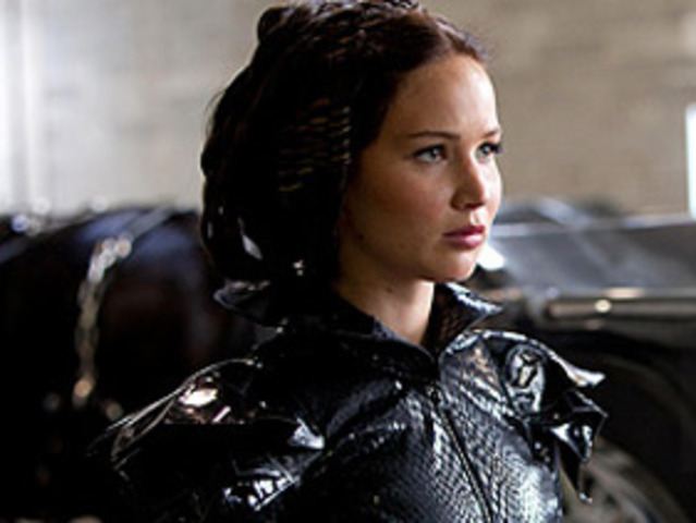 Cinna helps Katniss with her costume
