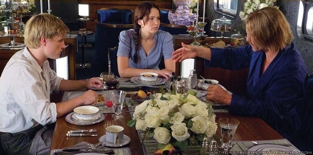 Katniss and Peeta meet Haymitch, their mentor, on the train.
