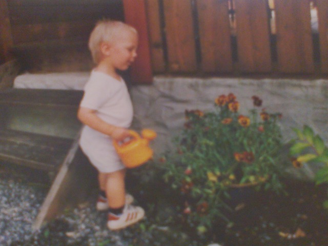 Thomas is watering the flowers in our garden with his mom in Norway, Hønefoss