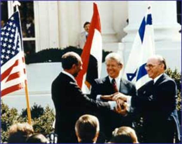 Jimmy Carter brings President Anwar el-Sadat of Egypt and Prime Minister Menachem Begin of Israel to the White House to celebrate the signing of a peace treaty between the two nations