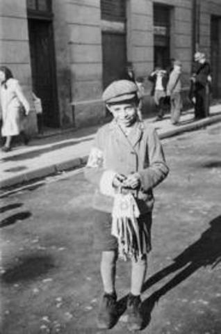 Germans force Jews in Poland to wear a yellow Star of David on their chests or a blue-and-white Star of David armband