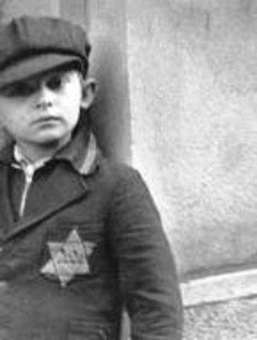 Germans force Jews in Poland to wear a yellow Star of David on their chests or a blue-and-white Star of David armband.