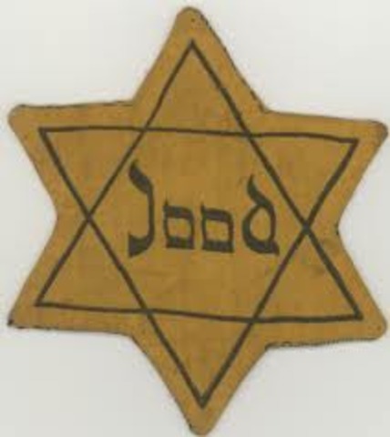Germans force Jews in Poland to wear a yellow Star of David on their chests or a blue-and-white Star of David armband.