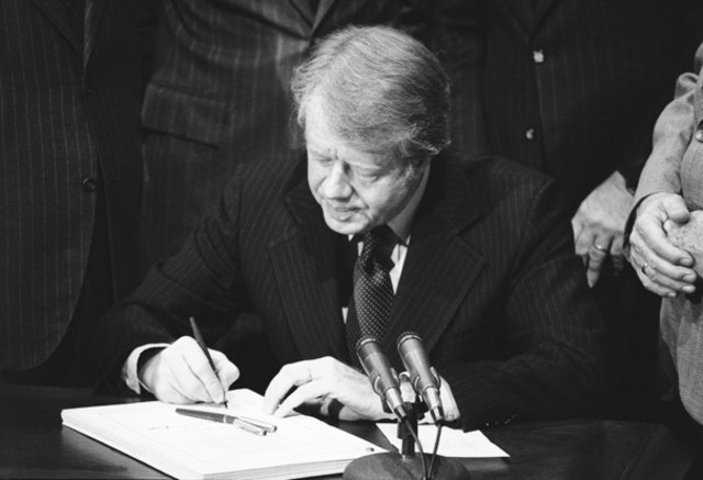 Signs a Social Security Bill that increases taxes.