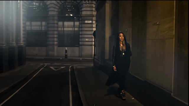 The wide shot further depicts the cittyscape setting and gives the viewer a full view of her costume; a black hoodie and black jeans suit the night time look of the video