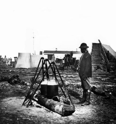 African American army cook working over an open fire at City Point, Virginia, during the siege of Petersburg in the Civil War.