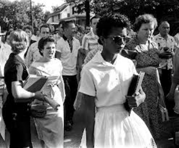 Soldiers escort nine African American students to desegregate a school in Arkansas.