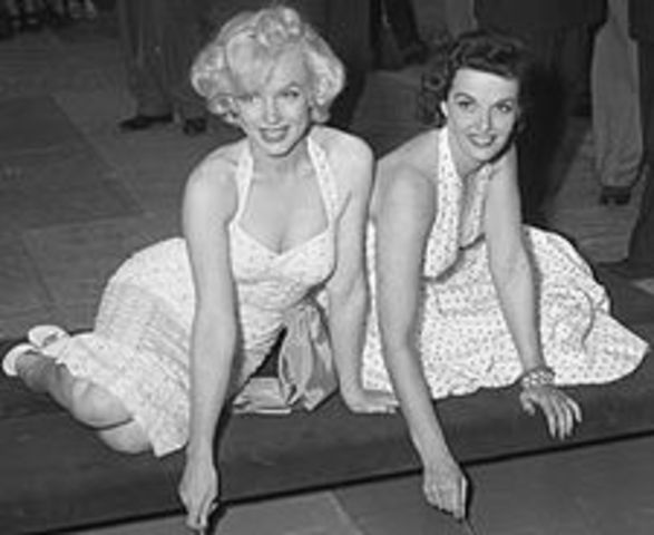 Marilyn Monroe and Jane Russell press their hands and feet in the cement in the forecourt of Grauman's Chinese Theatre