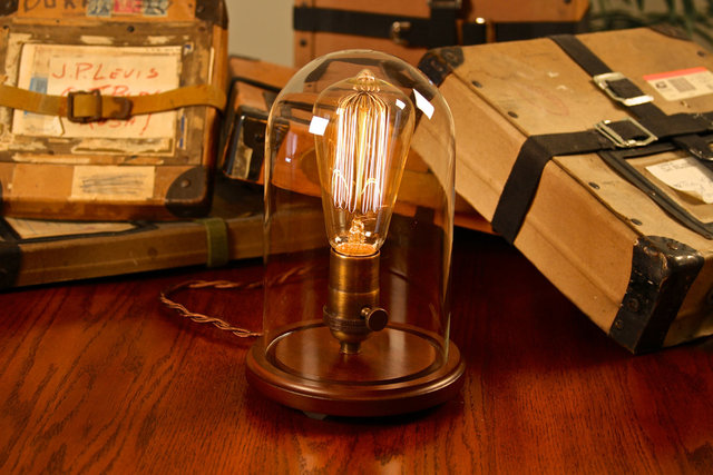 Thomas Edison uses light bulb to light lamp