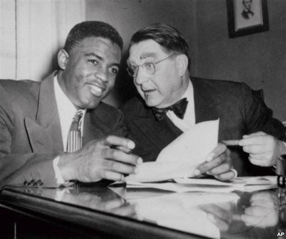 Jackie Robinson signs baseball contract with the Brooklyn Dodgers.