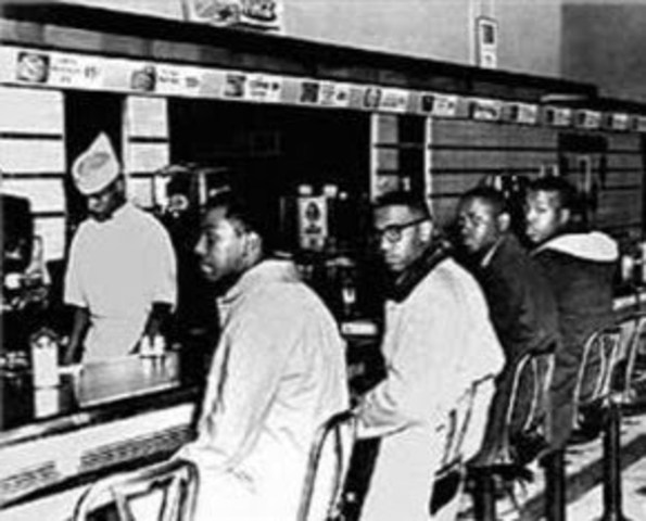 Four college students demonstrate first sit-in