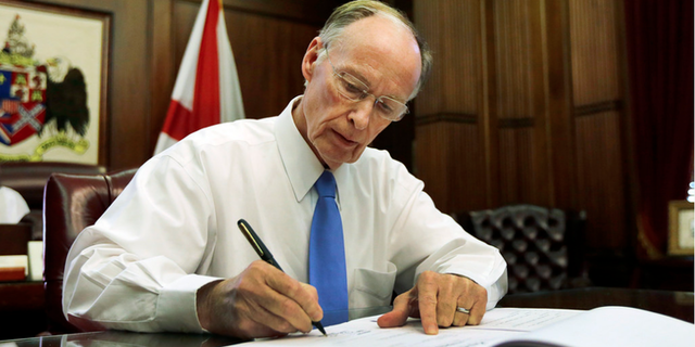 Robert Bentley signs legislation pardoning all Scottsboro Boys.
