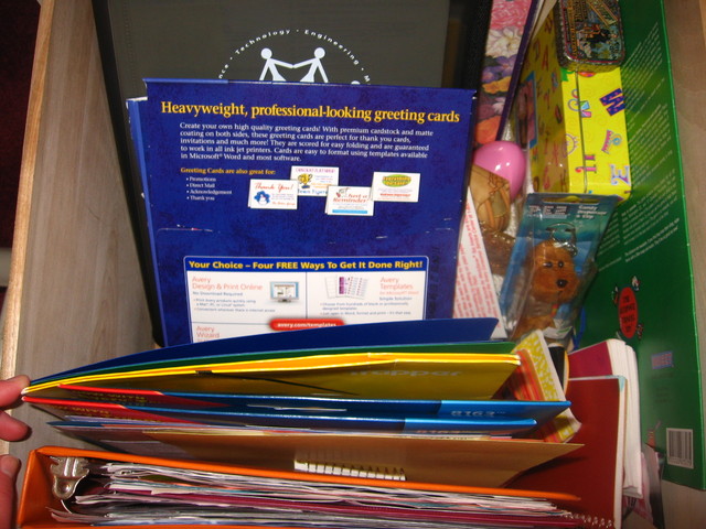 Clear out bottom desk drawer and use old binders to store misc. papers