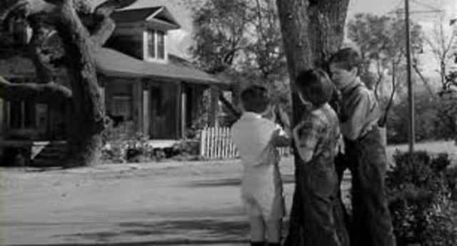 Jem, Scout, and Dill try to look in the Radley house