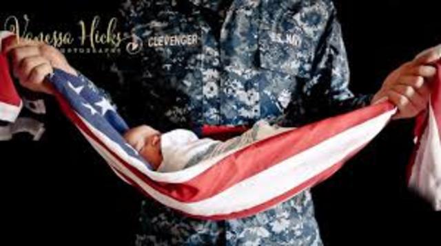 Infant being held by his father in the american flag