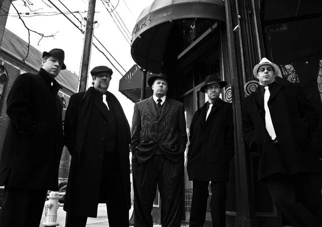 Bruno, Helmut, und Felix bauen eine Barrikade. Dann, das Auto hält an und der Gangsters kommen. Alfred nimmt ein Foto, und sie sind erwischt.