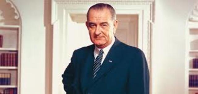 A bill adding a 10 percent surcharge to income taxes and reducing government spending is signed by President Johnson