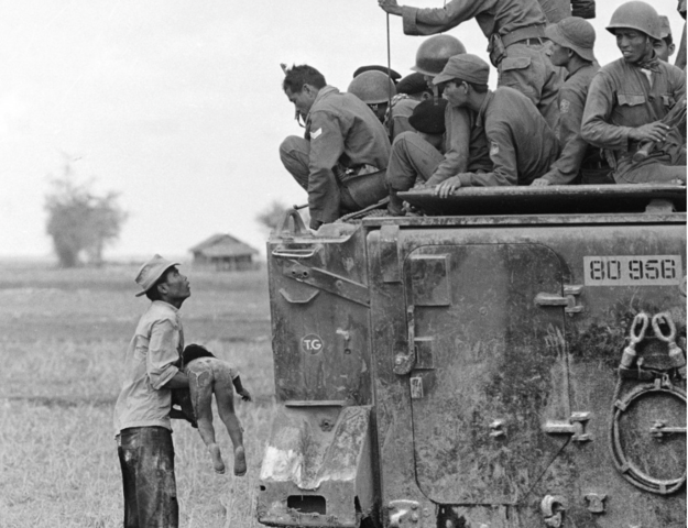 Father holds deceased child as South Vietnamese Army Rangers look down