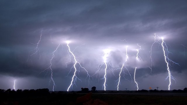 Benjamin Franklin tests his theory, fastening an iron spike to a silk kite and holding the end of the kite string by an iron key during a thunderstorm.