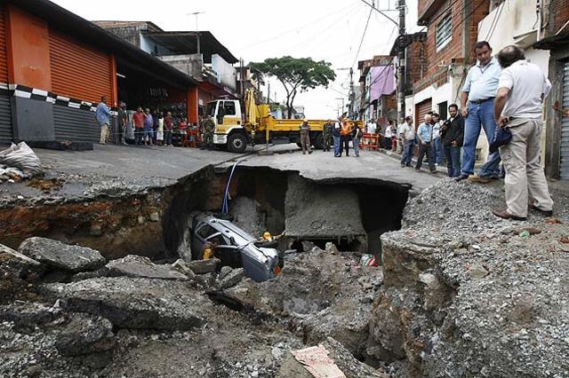 Carro cai em cratera abertura na rua Daniel Klein após temperal na zona Sul de São Paulo