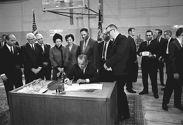 President Johnson signs the Higher Education Act.