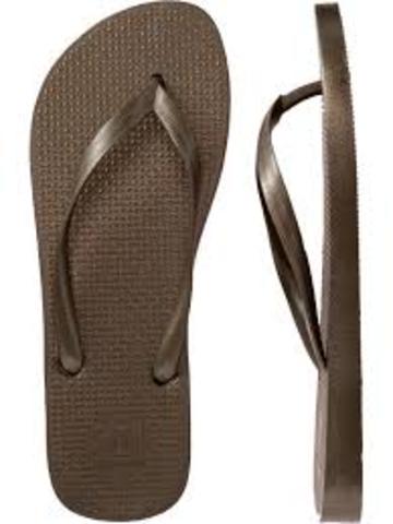 Chancleta. Descripción: Tipo de sandalia hecha de una suela que se sostiene al pie por medio de una tira o cordón.