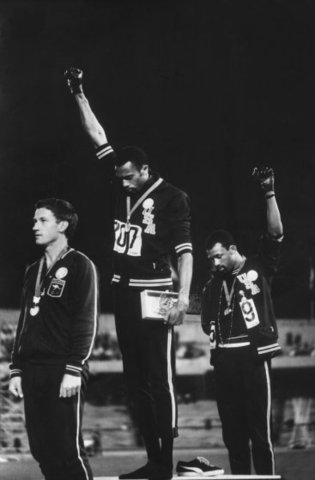 Tommie Smith and John Carlos raise their fists in recognition of racial inequality in the US. Australian Peter Norman stands in solidarity with them.