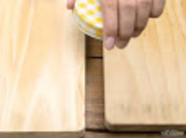 colocar la tapa del frasco boca abajo entre los bloques de madera