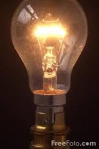 Thomas Edison uses a light bulb to light a lamp.