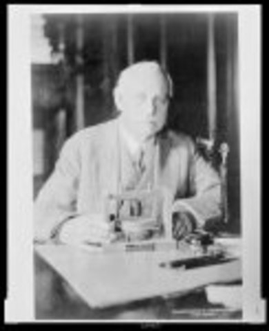 Charles J. Bell holding the First Telephone