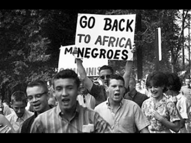 when they go back to school again there are white people from all over town holding up rude signs