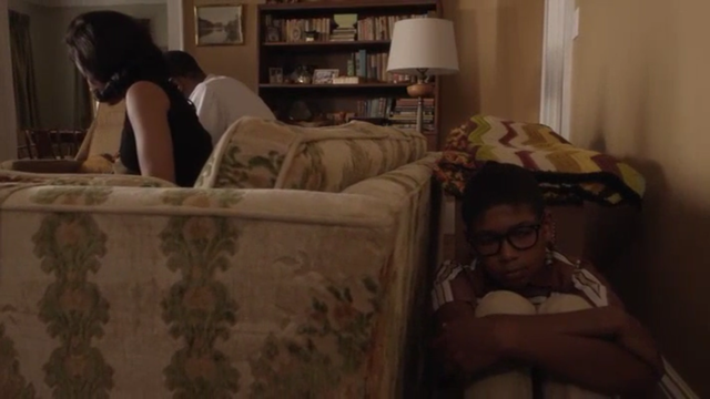 Kenny hides behind the couch