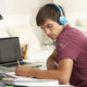 42164518 teenage boy studying at desk in bedroom wearing headphones stock photo